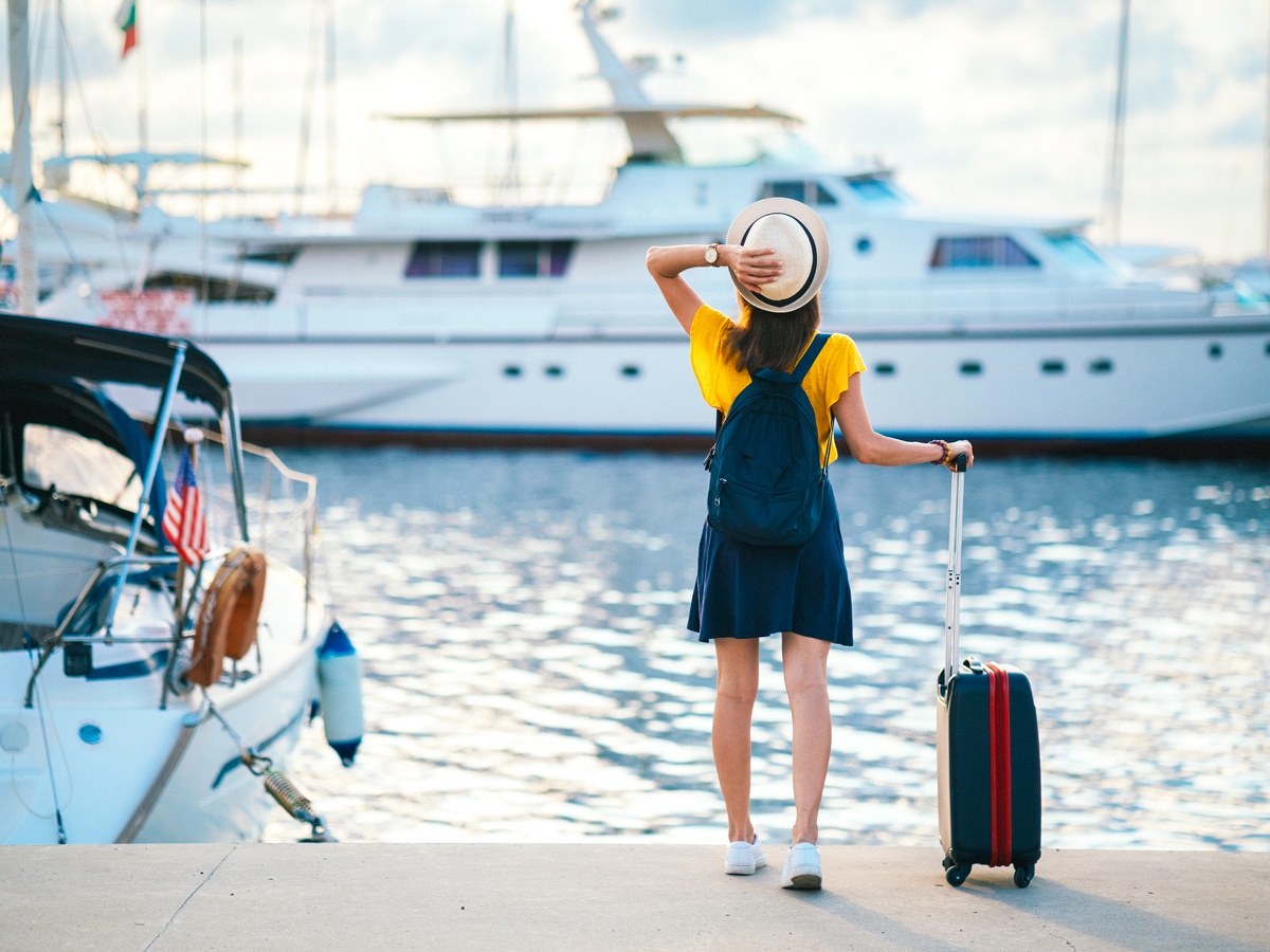 Traveler standing on dock with suitcase