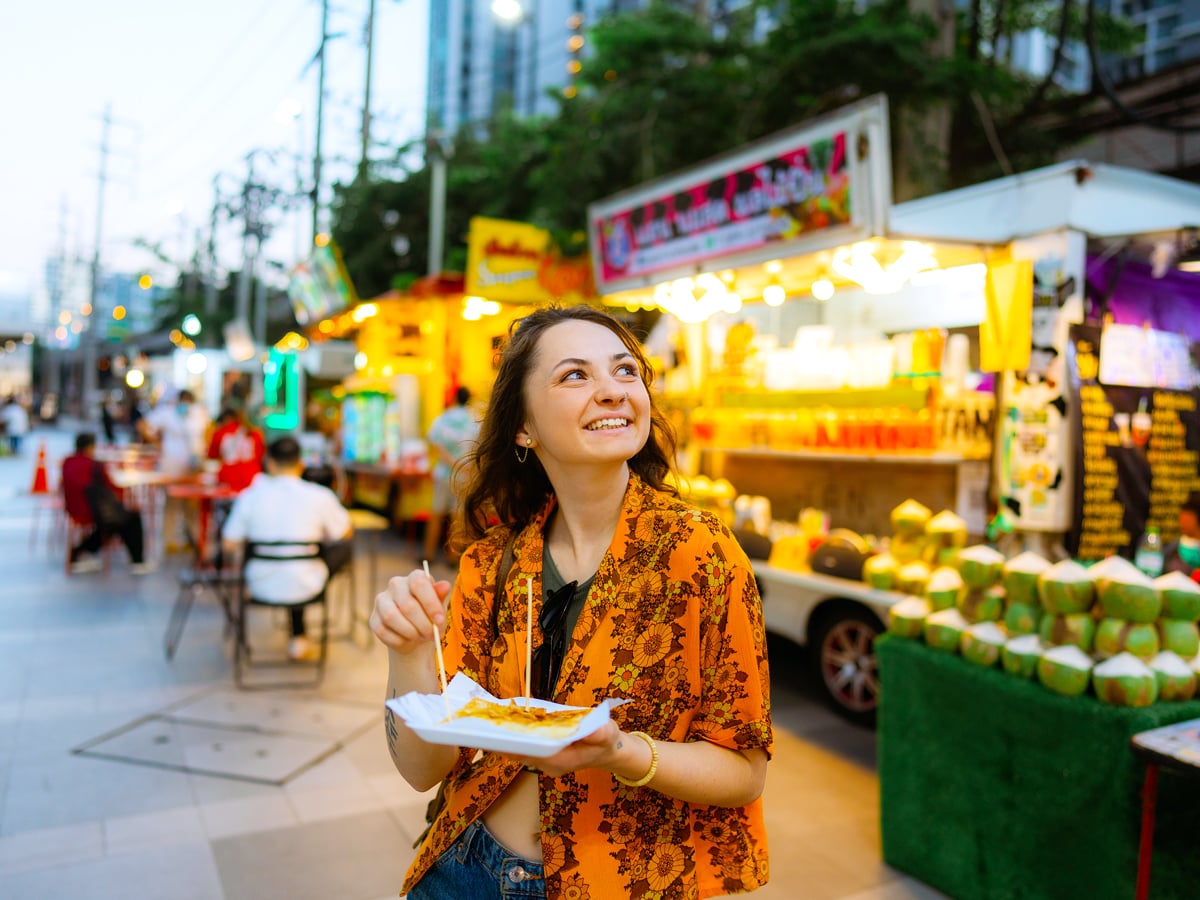Woman eating at outdoor food market