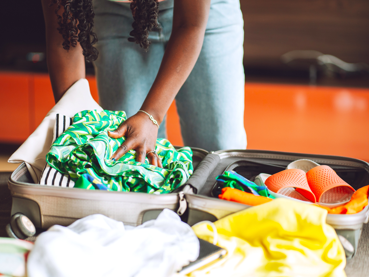 Traveler packing clothes in suitcase