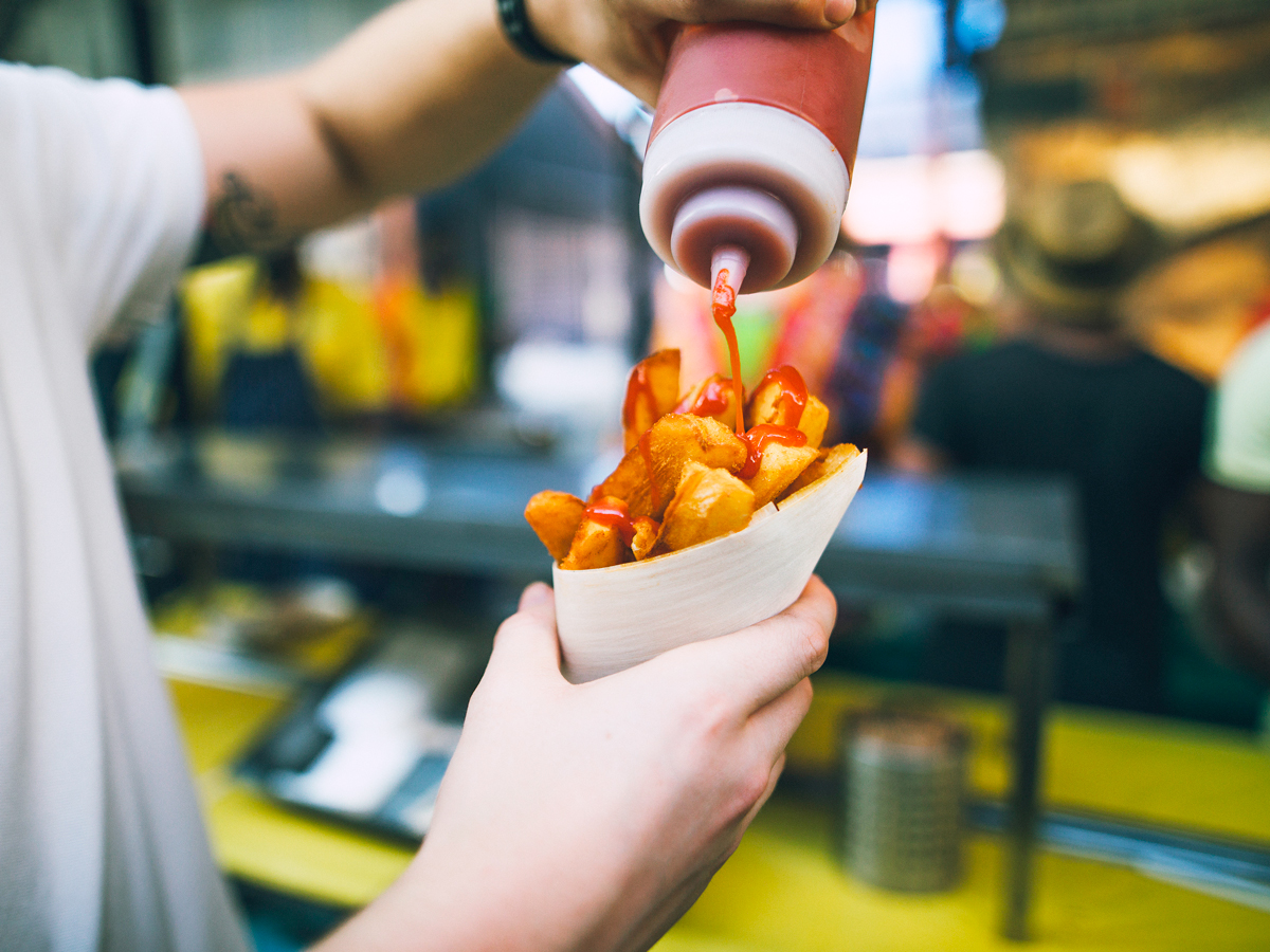 Diner putting ketchup on French fries