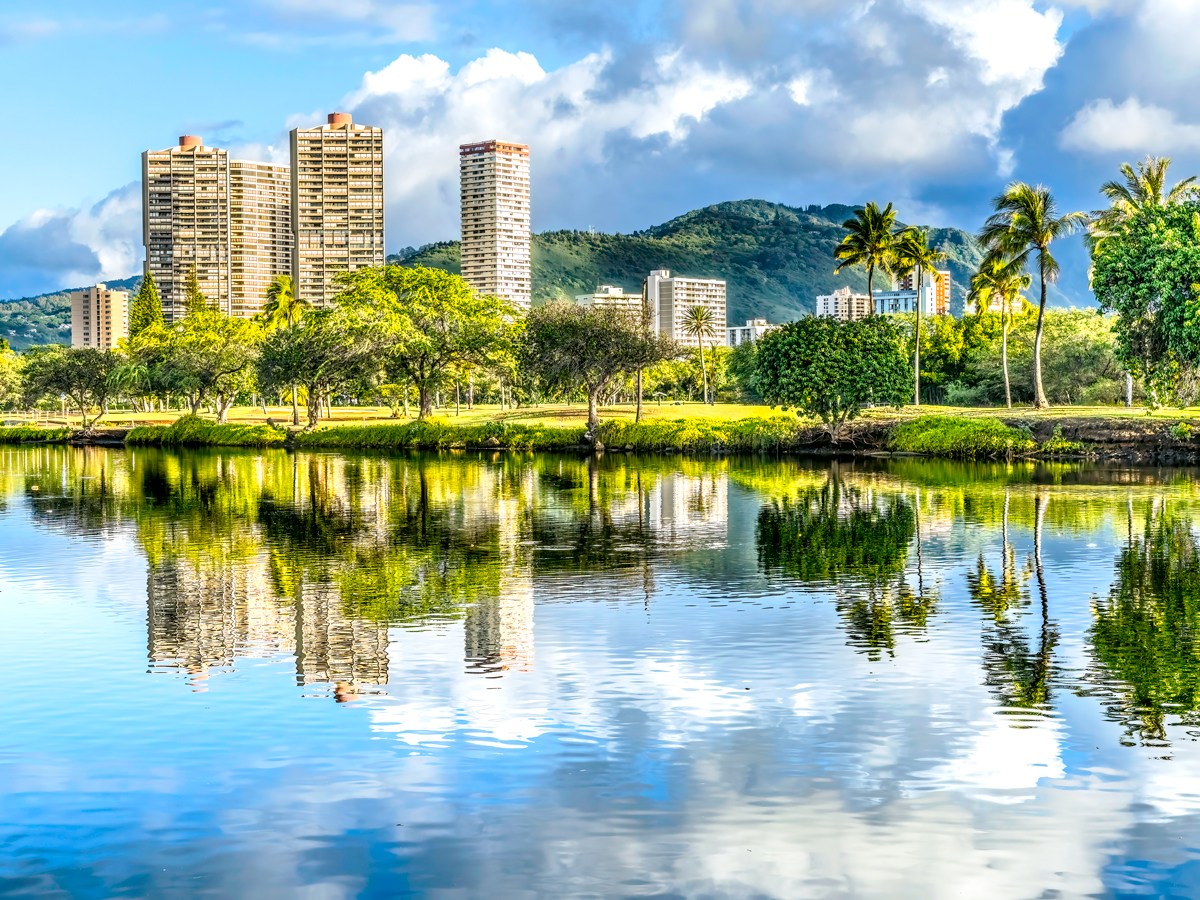 High-rises and palm trees reflecting on water in Honolulu, Hawaii