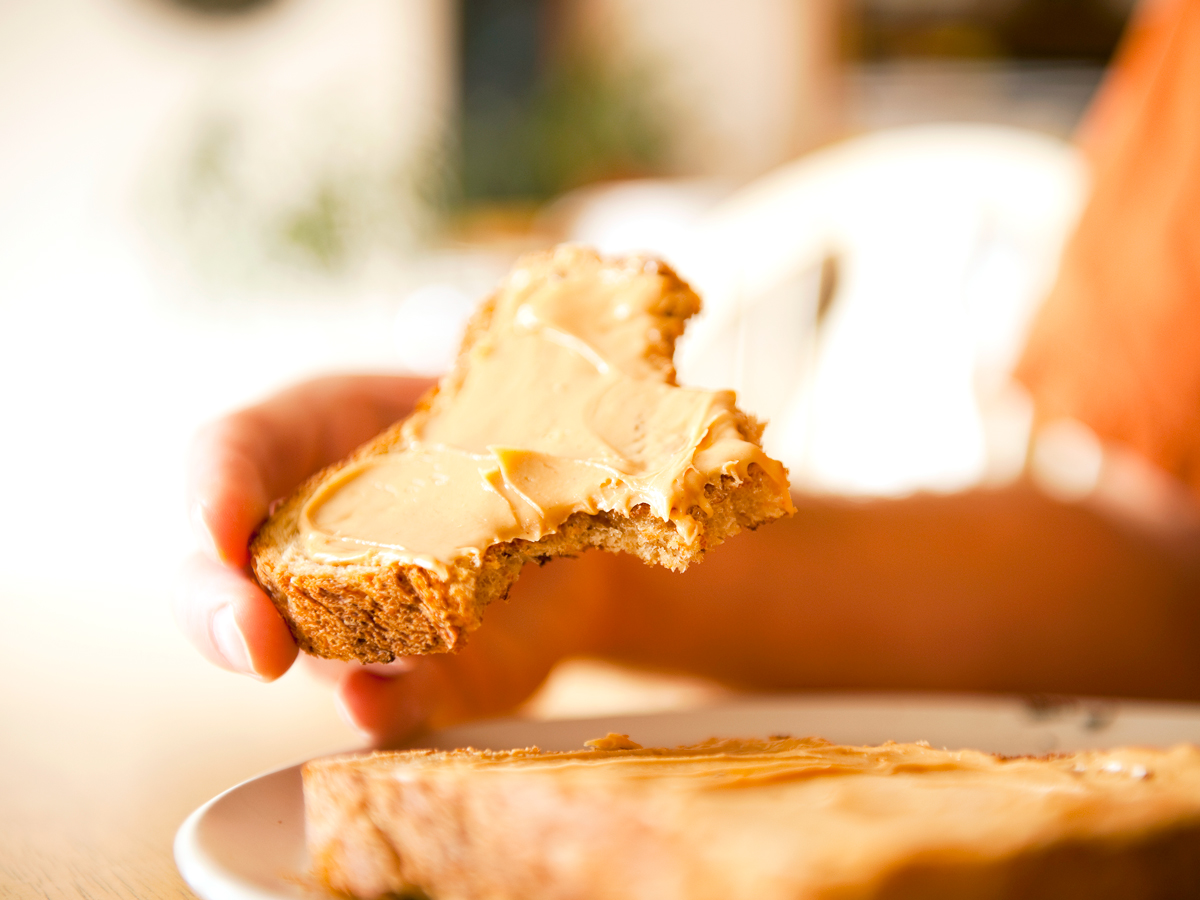 Person eating bread with peanut butter