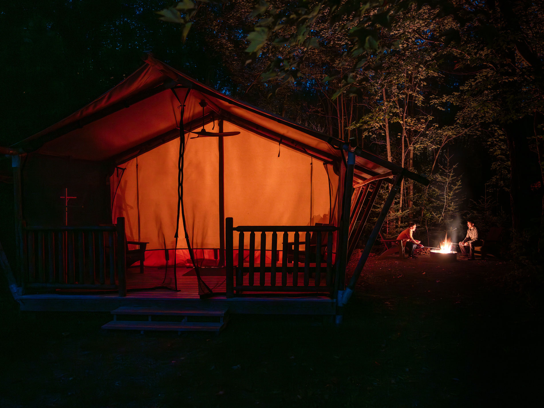 Glamping tent illuminated at night at Terramor Outdoor Resort in Maine