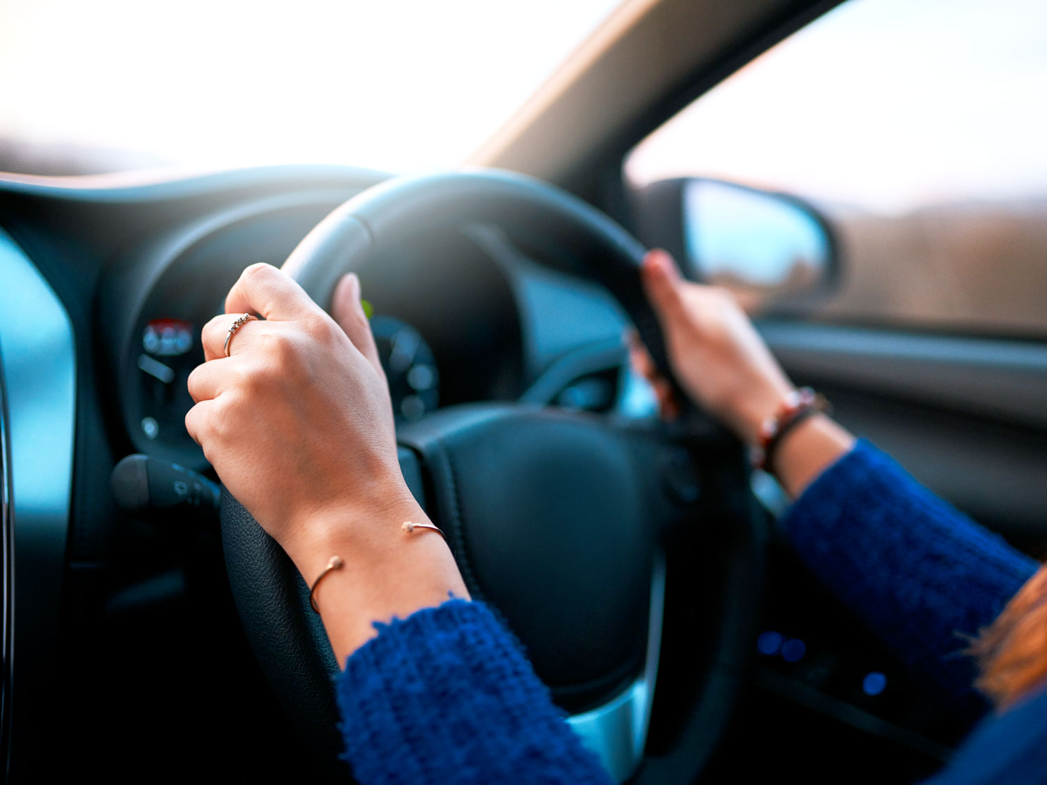 Driver with hands on car's steering wheel