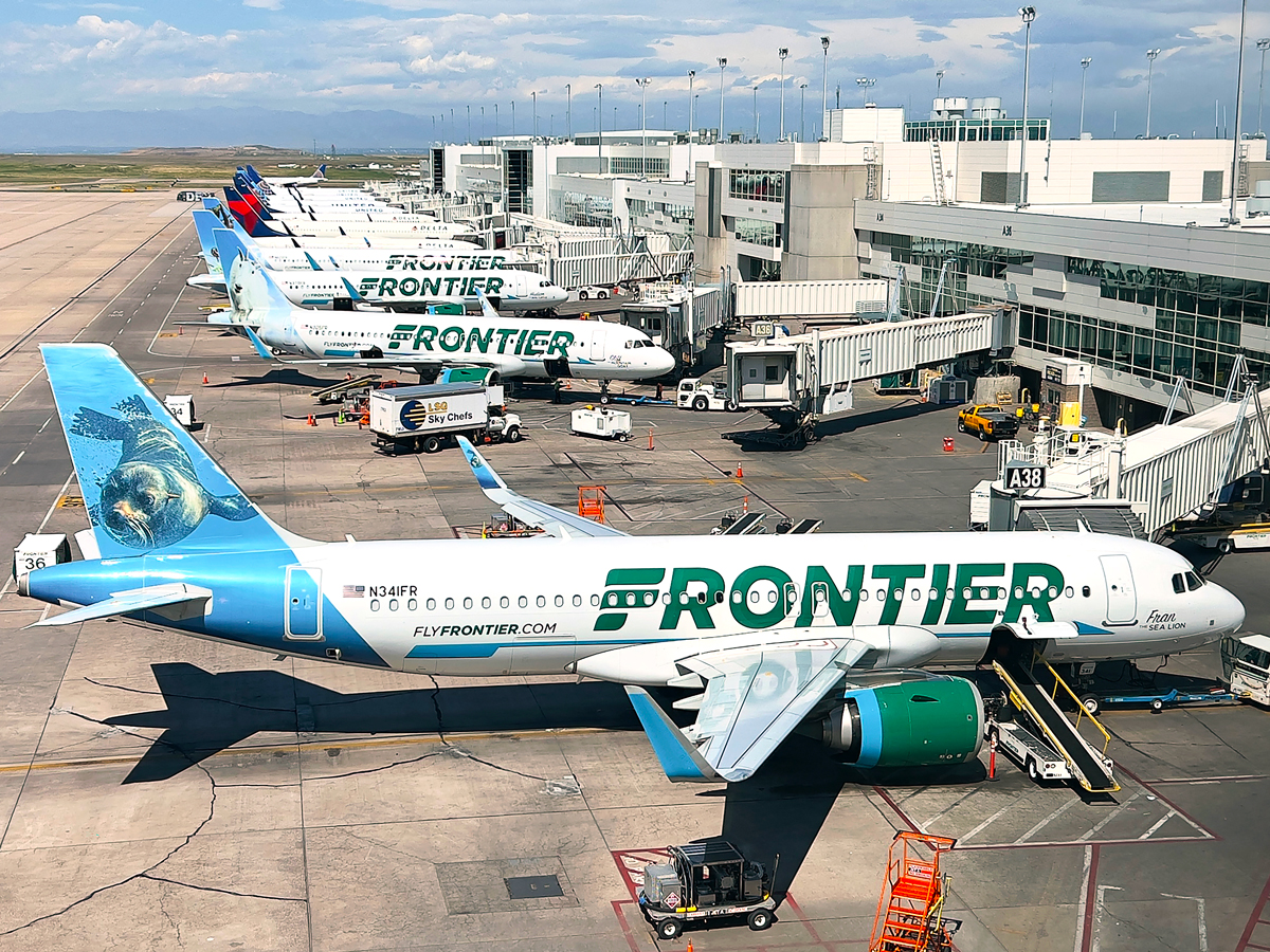 Frontier Airlines aircraft parked at terminal at Denver International Airport