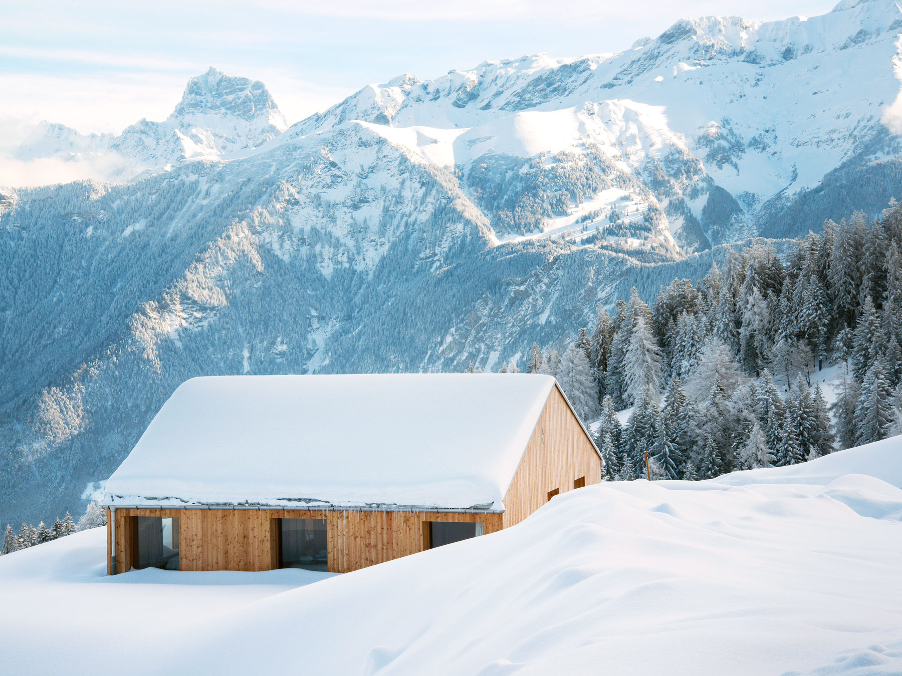 Snow-covered cabin surrounded by the Swiss Alps