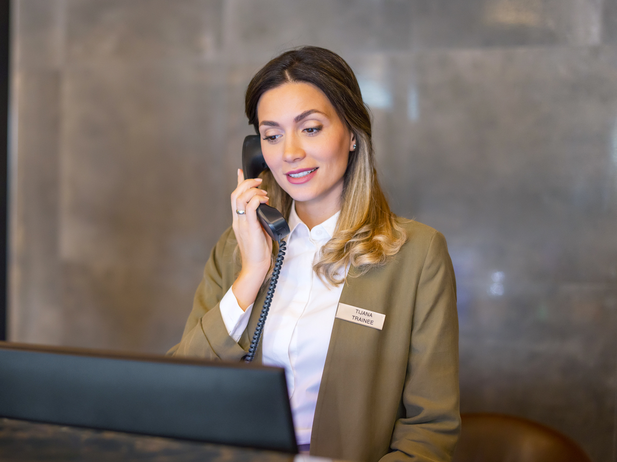 Hotel front desk employee speaking on phone