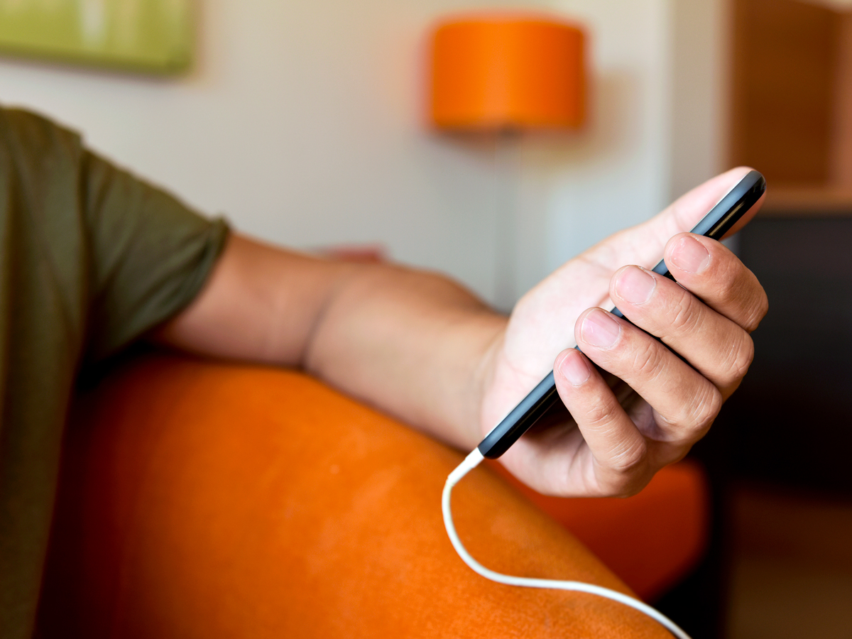 Person using cellphone with cable attached