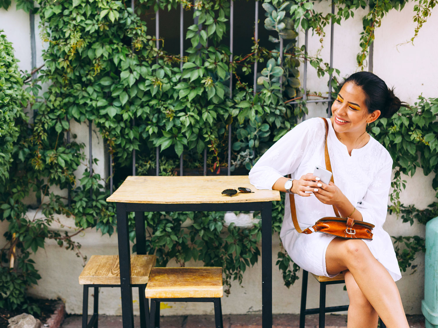 Woman sitting at outdoor table in flowy dress