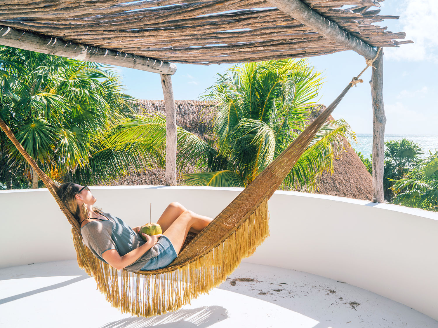 Woman lounging in hammock under shade