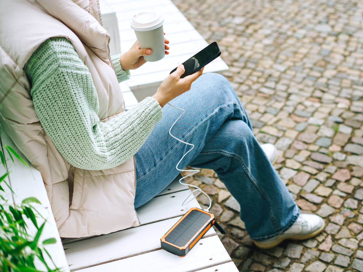 Person using cellphone plugged into power bank