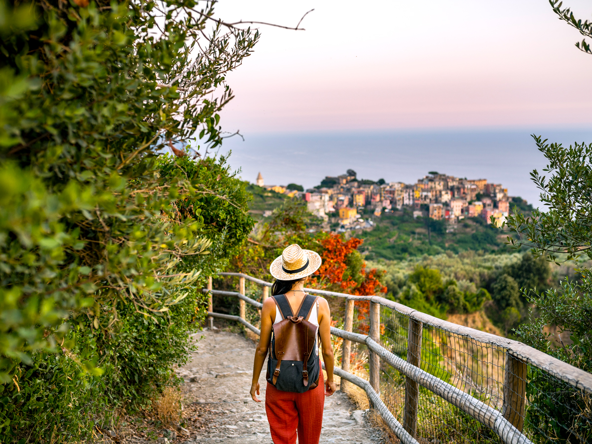 Traveler walking on path overlooking coastal village