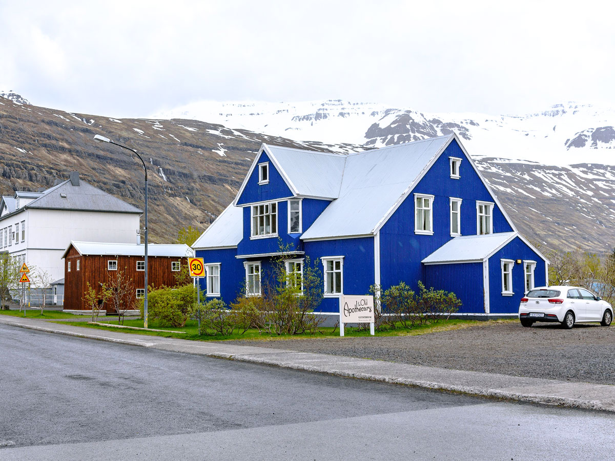 Blue house in Iceland near snow-capped mountains
