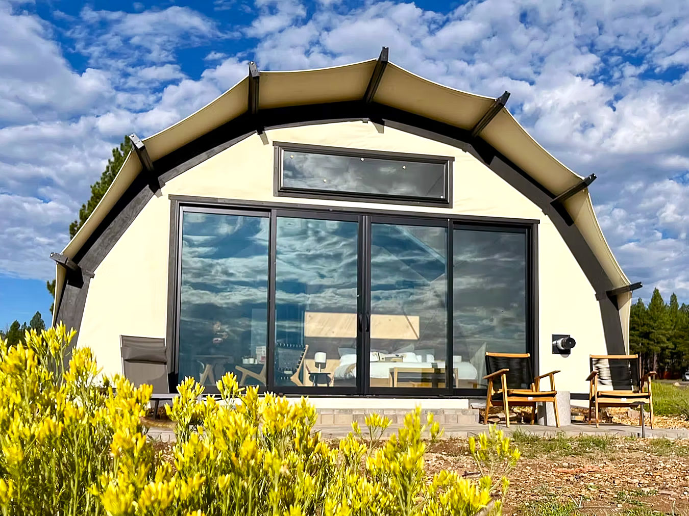 Glamping tent under partly cloudy skies at Backland in Arizona