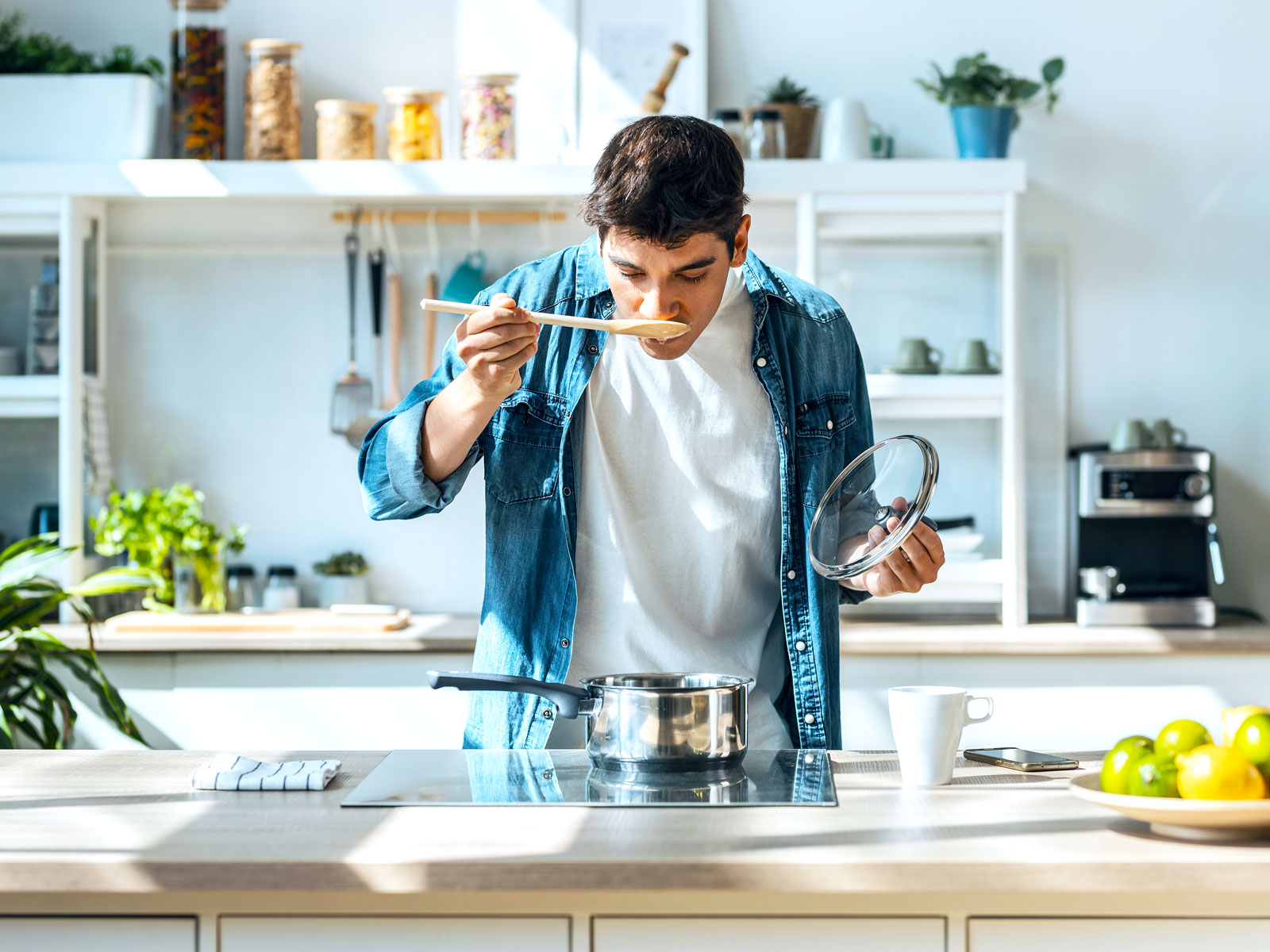Home chef tasting food on stovetop