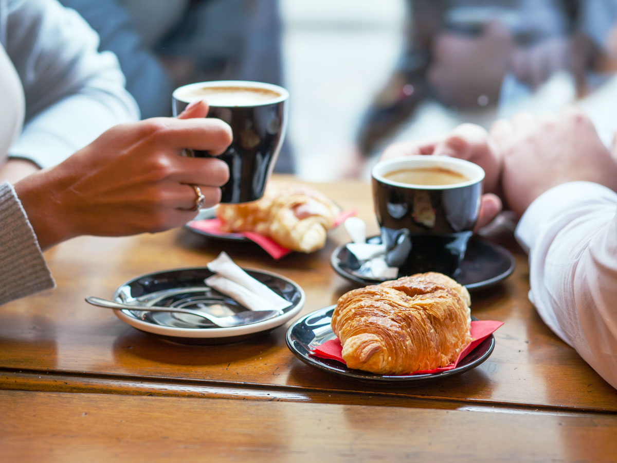 Two people drinking coffee and eating pastries