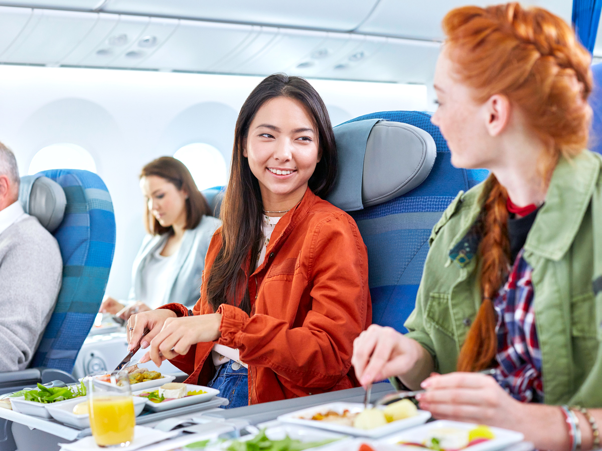 Passengers eating meals on seatback tray tables