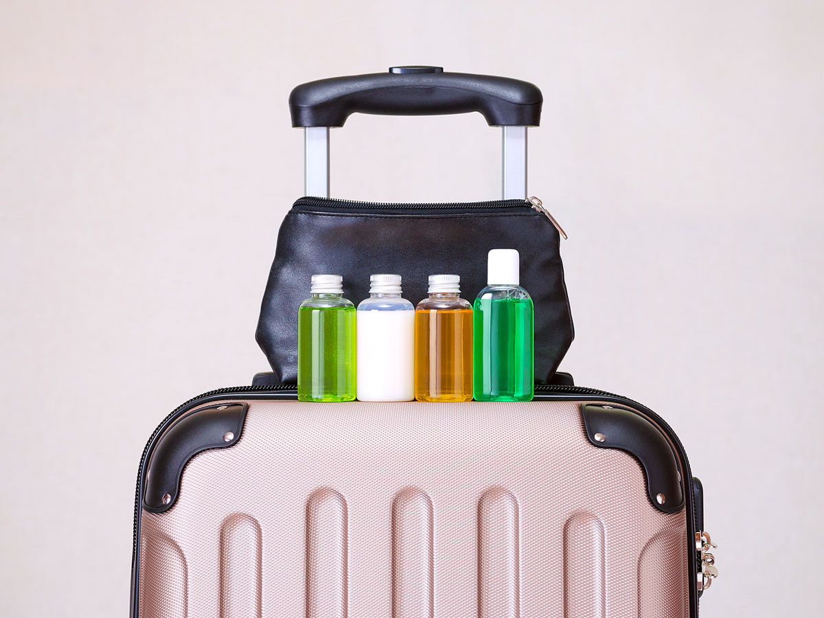 Travel-size liquid containers atop suitcase