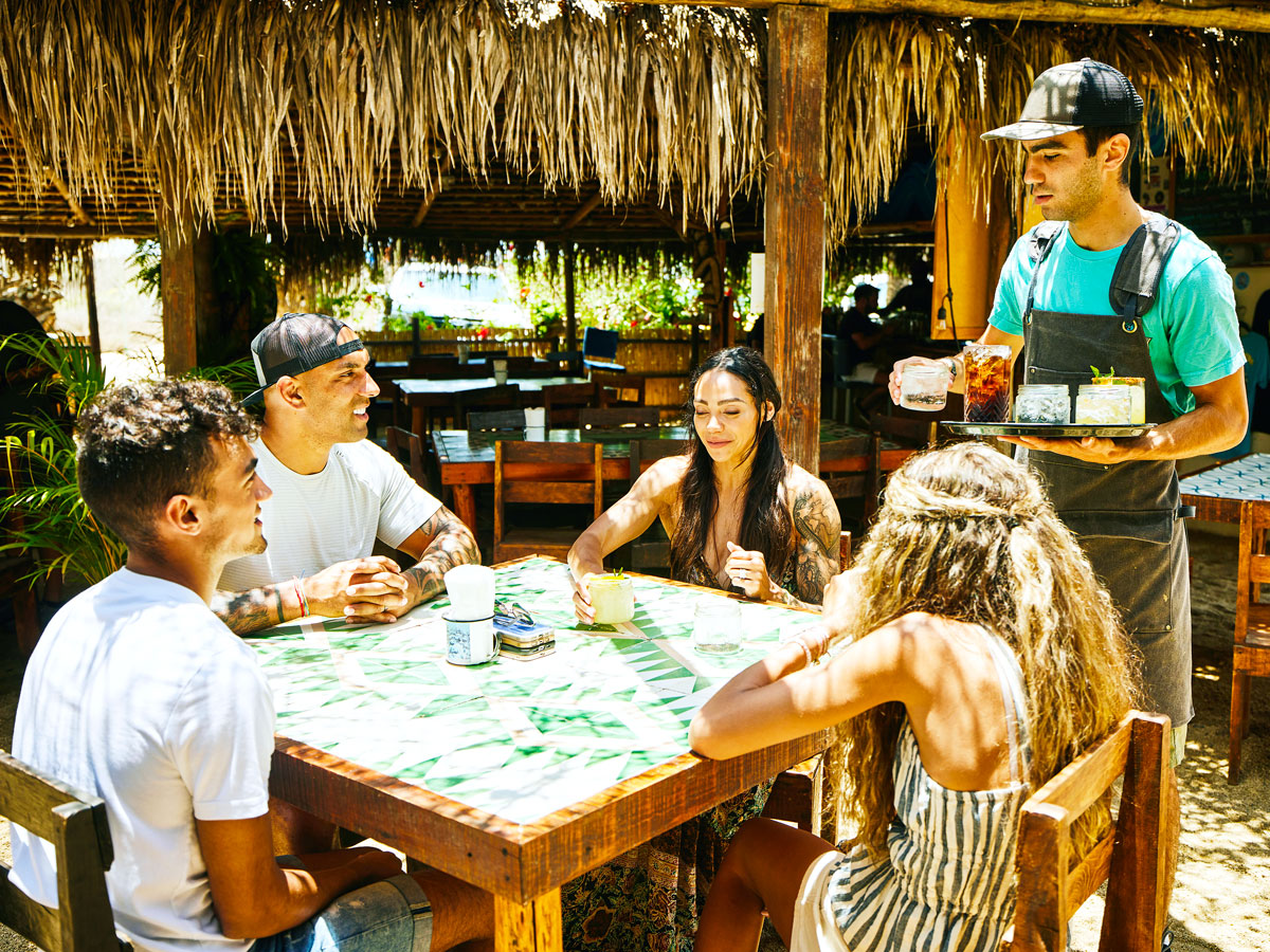 Waiter serving drinks to group dining outdoors