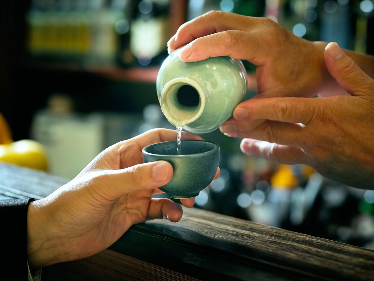 Person pouring sake into another person's glass