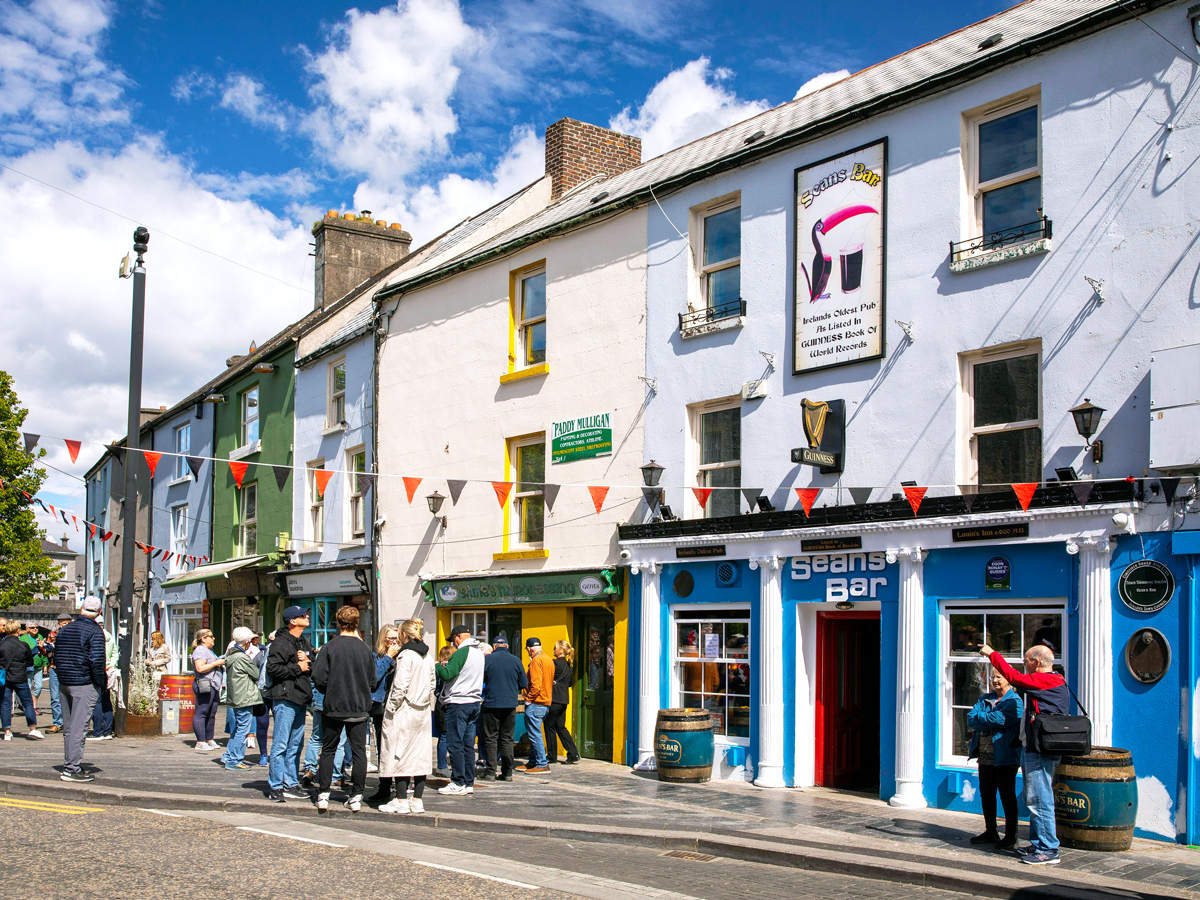 People gathered on sidewalk outside of Sean's Bar in Athelone, Ireland