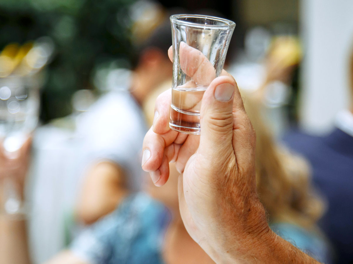 Person holding empty shot glass