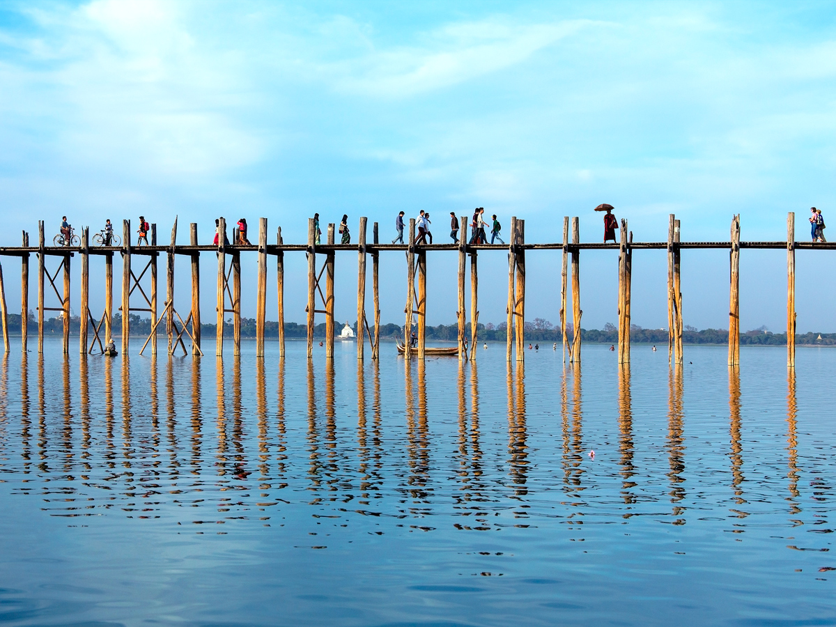 People walking across U Bein Bridge in Myanmar