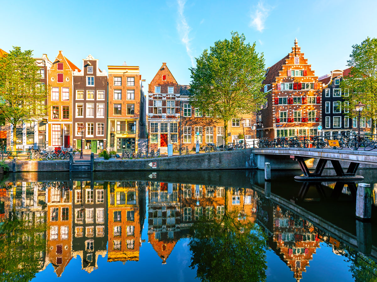 Row homes reflecting on canal in Amsterdam, the Netherlands