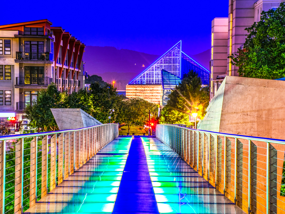 Glass bridge lit in bright colors in downtown Chattanooga at night