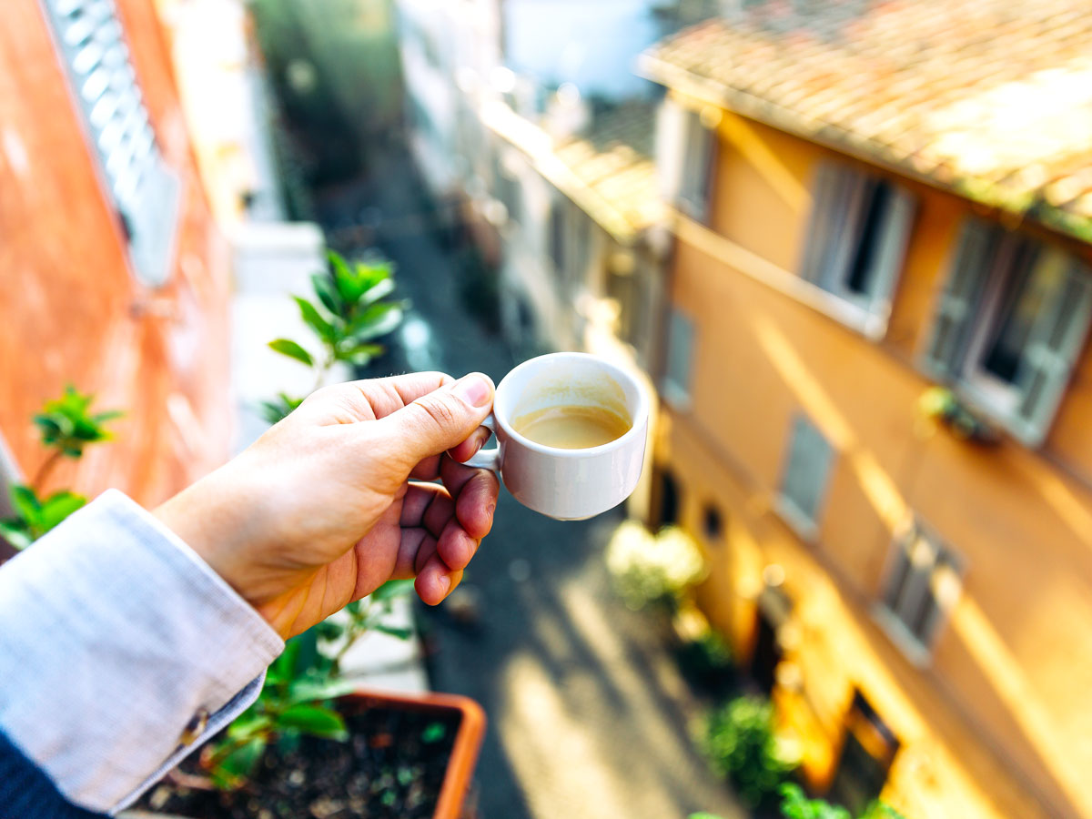 Person drinking espresso on balcony