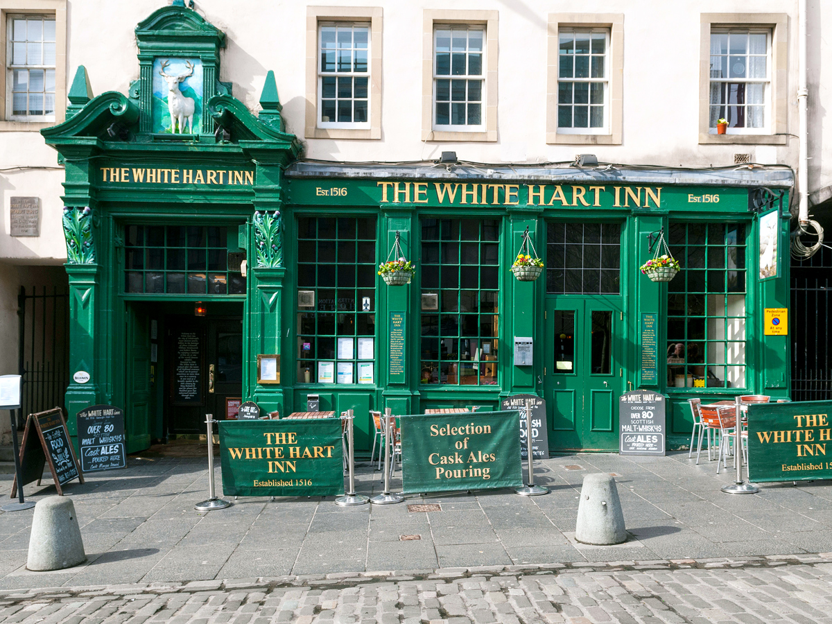 Patio and green-painted exterior of the White Hart Inn in Edinburgh, Scotland