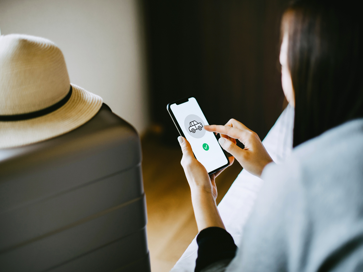 Person booking car rental on cellphone