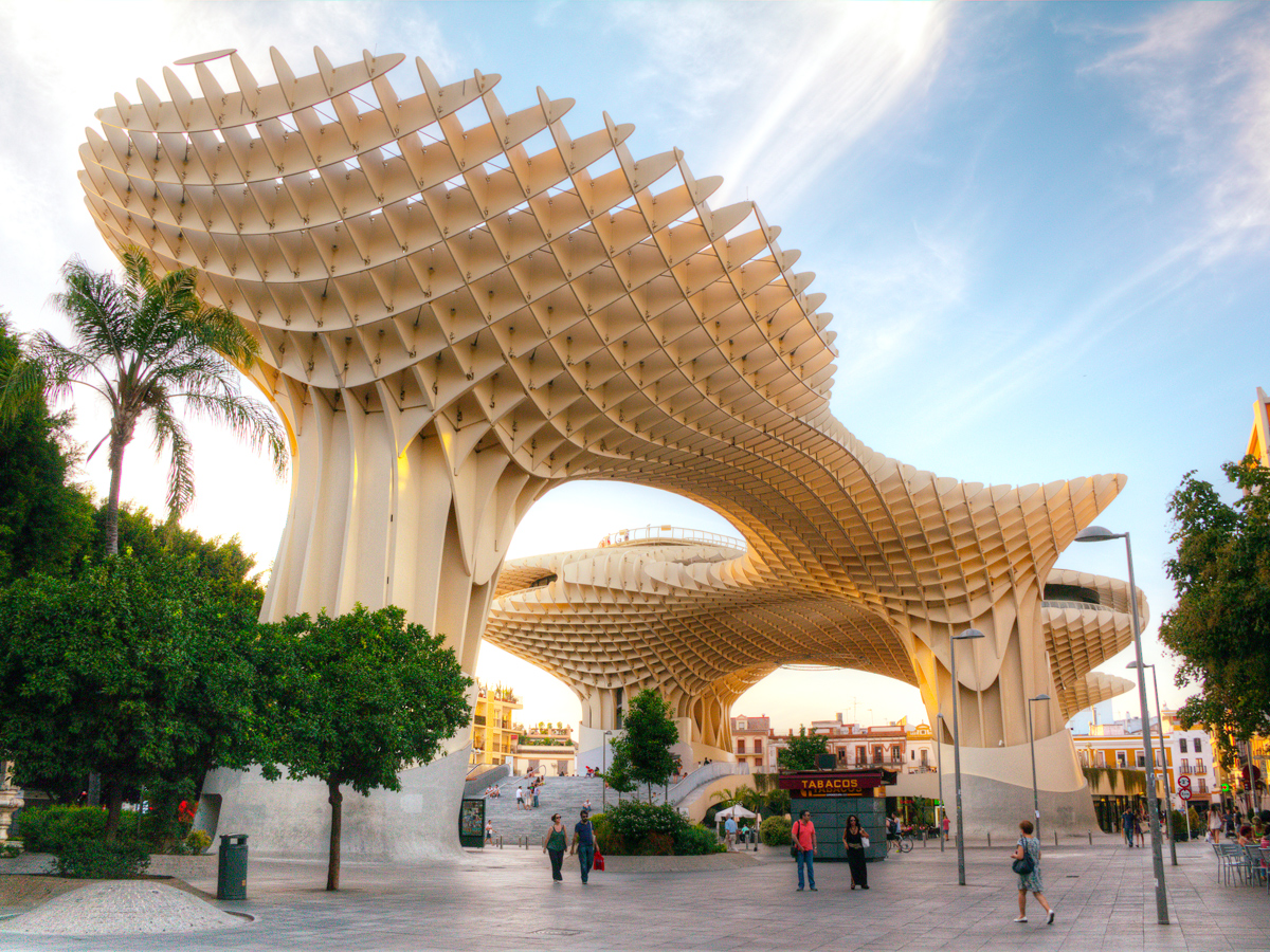 Pedestrians walking under the Metropol Parasol in Seville, Spain