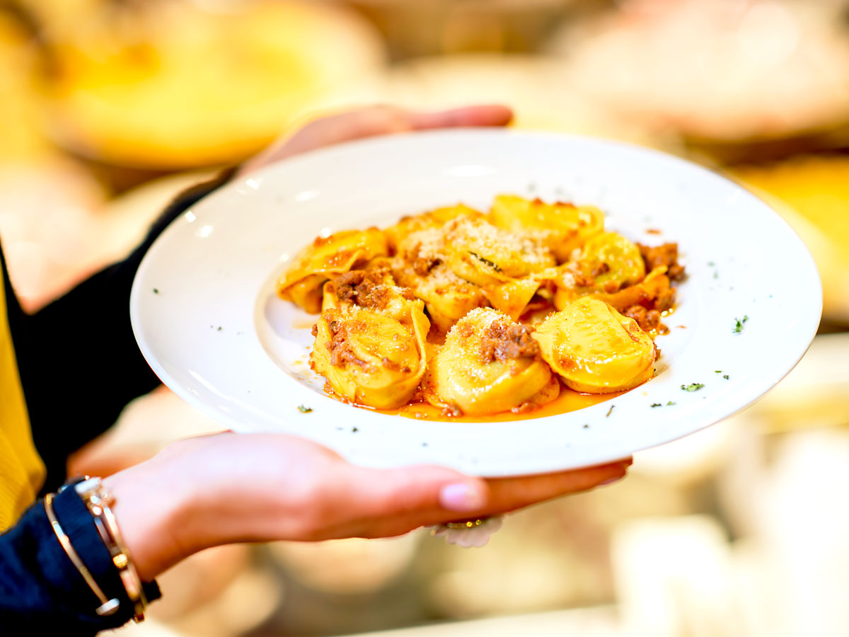 Person holding dish of pasta