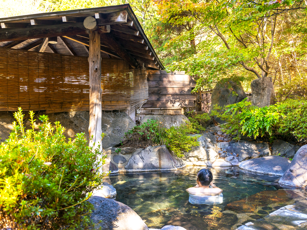 Guest bathing in onsen at traditional Japanese ryokan