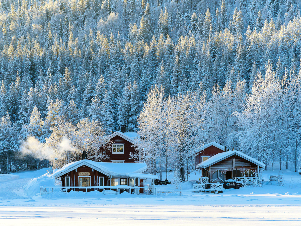 Snow-covered sauna and guesthouse at Immelkartano in Finland