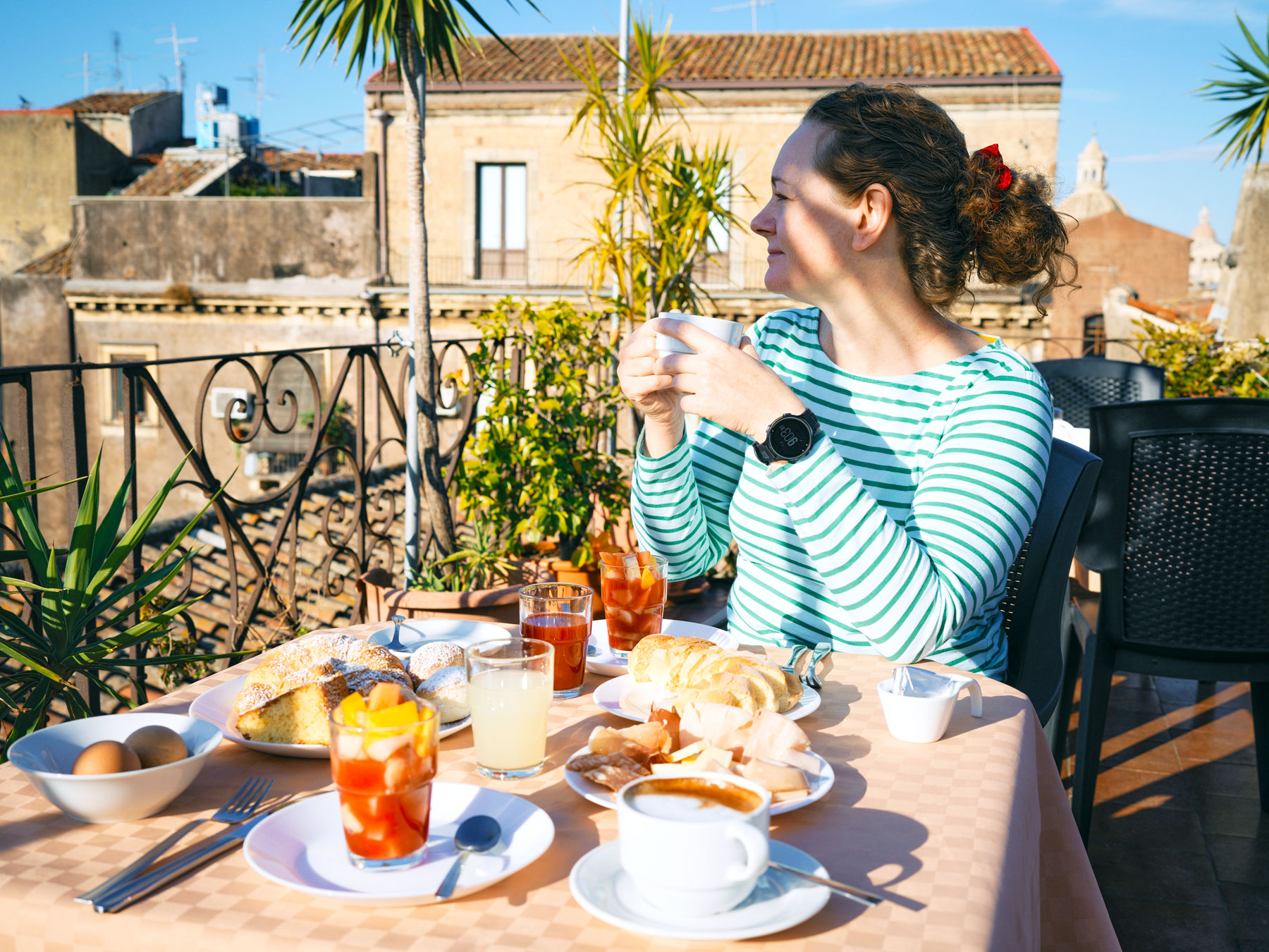 Woman drinking coffee and eating breakfast on terrace