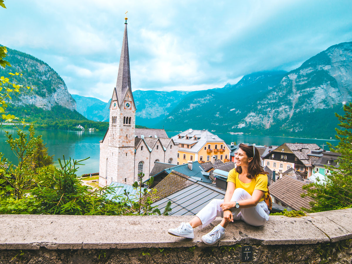 Woman sitting on bench overlooking Hallstatt, Austria