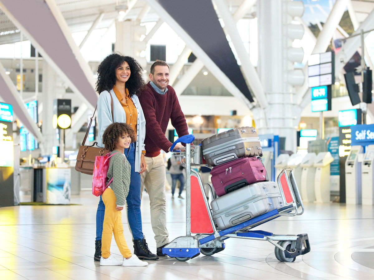 Family walking through airport with suitcases