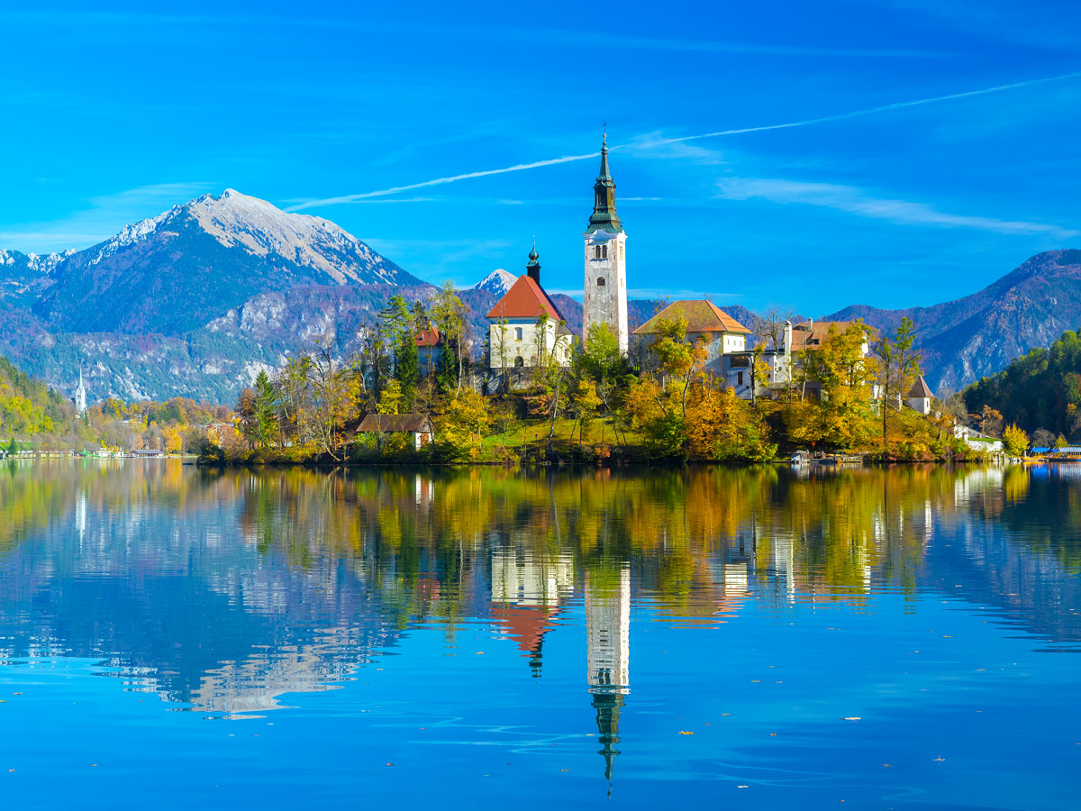 Church on small island in Lake Bled, Slovenia, with reflection on water's surface