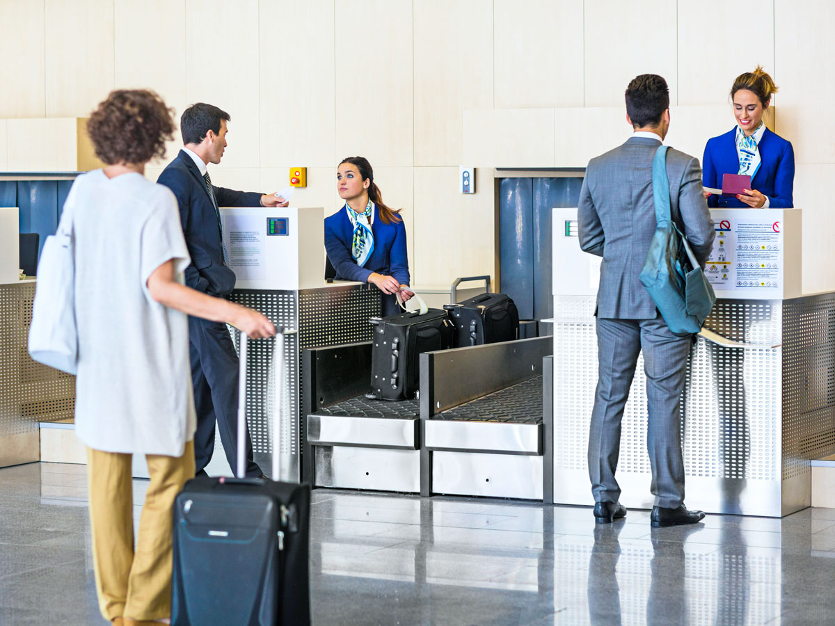 Passengers waiting in line to check bags at airport
