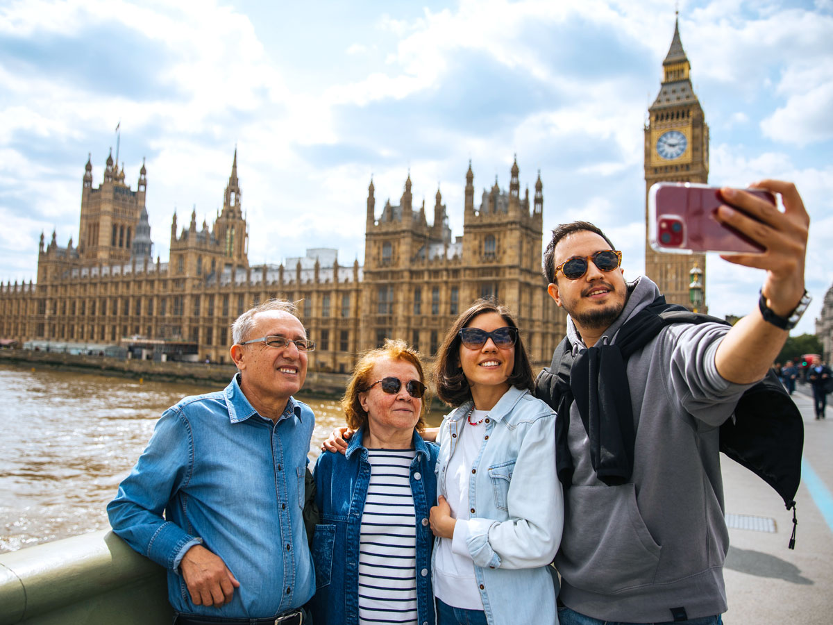 Family taking selfie in front of Big Ben and Palace of Westminster