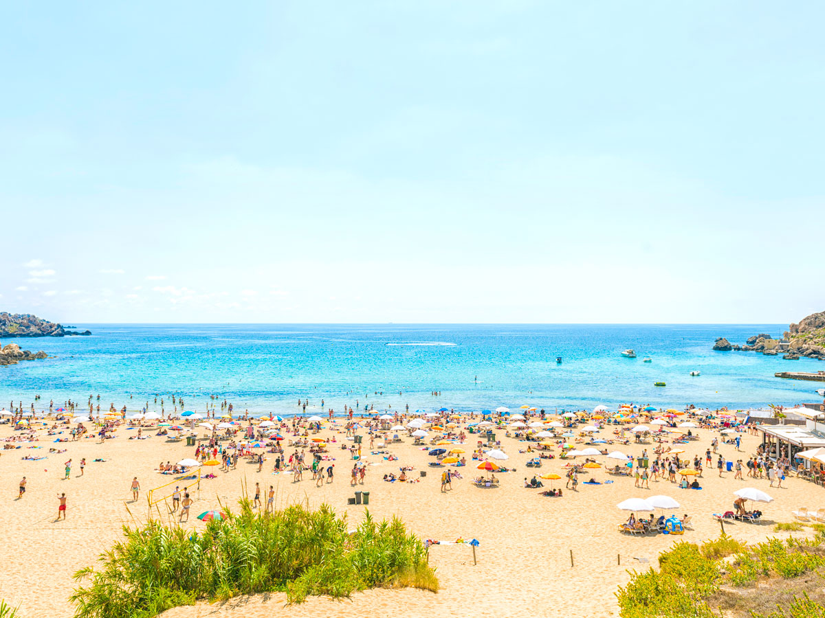 Crowded beach under sunny skies in Malta