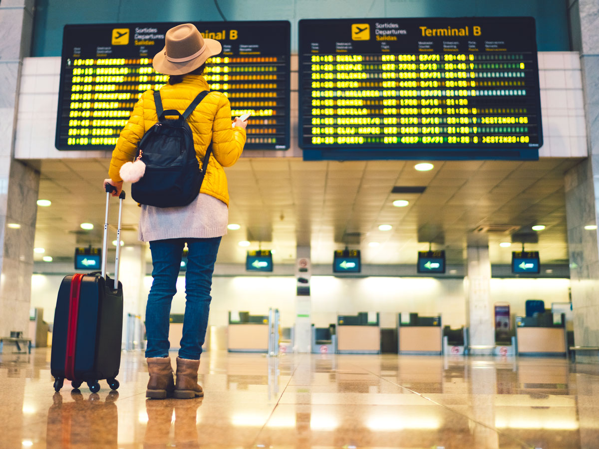 Traveler looking at flight status board in airport