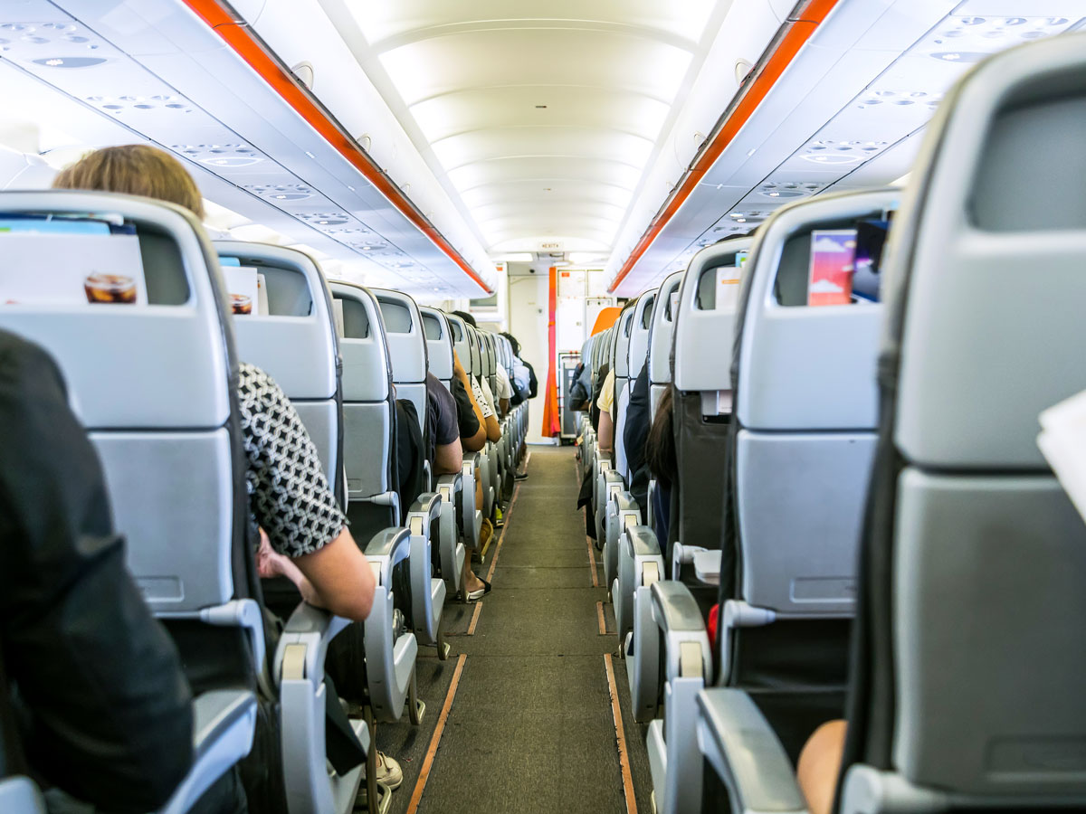 Aircraft aisle looking toward front of cabin