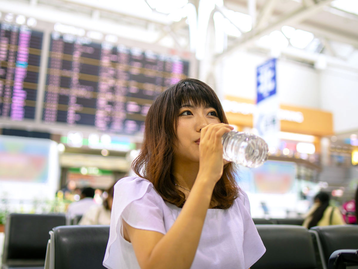 Traveler drinking bottled water in airport terminal
