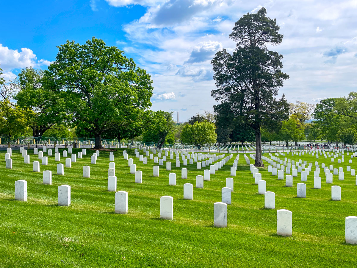 White tombstones in grassy field at Arlington National Cemetery in Virginia