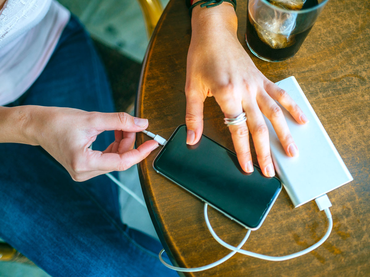 Person plugging phone into portable charging bank