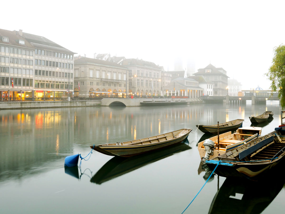 Boats moored in river on foggy day in Zurich, Switzerland