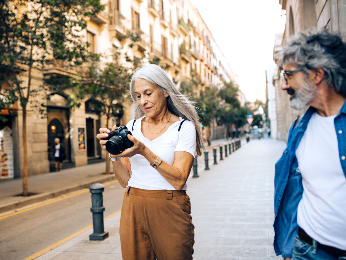 Woman standing on street holding camera